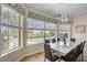 Dining room with natural light, contemporary light fixture, and view of the pool, perfect for Gathering meals at 7388 Gathering Ct, Reunion, FL 34747