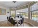 Contemporary dining room with modern light fixture, neutral color palette, and view of the pool creating an elegant ambiance at 7388 Gathering Ct, Reunion, FL 34747