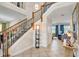 Grand foyer showcases an elegant staircase with wooden railing and iron spindles, complemented by neutral tile flooring at 7388 Gathering Ct, Reunion, FL 34747