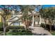 Beautiful two-story home with mature trees, lush landscaping, and a brick paver driveway at 7388 Gathering Ct, Reunion, FL 34747
