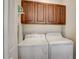 Laundry room with front load washer and dryer plus overhead cabinets at 7388 Gathering Ct, Reunion, FL 34747