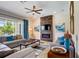 Modern living room featuring a stone fireplace, comfortable seating, and large windows at 7388 Gathering Ct, Reunion, FL 34747