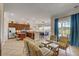 Open-concept living space featuring a kitchen with stainless steel appliances, bar seating, and cozy lounge area with natural light at 7388 Gathering Ct, Reunion, FL 34747