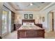 Bedroom with tray ceiling, ceiling fan, bedside lamps, and balcony access at 7388 Gathering Ct, Reunion, FL 34747