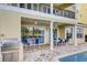 Covered patio with a built-in BBQ area and table for outdoor dining at 7388 Gathering Ct, Reunion, FL 34747