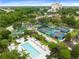 Aerial view showcasing the community's amenities: pools, tennis, and recreational areas surrounded by greenery at 7649 Heritage Crossing Way # 302, Reunion, FL 34747