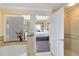 Bright bathroom with a view into the main bedroom and a glass-enclosed shower at 7649 Heritage Crossing Way # 302, Reunion, FL 34747