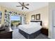 Bright main bedroom with private balcony overlooking a golf course and decorated with floral curtains at 7649 Heritage Crossing Way # 302, Reunion, FL 34747