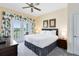 Comfortable main bedroom with private balcony and palm tree-themed curtains at 7649 Heritage Crossing Way # 302, Reunion, FL 34747