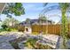 Stone patio with fireplace and metal arbor overlooks a screened pool in the backyard at 910 Cypress Ave, St Cloud, FL 34769