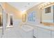 Bright bathroom featuring double vanities, soaking tub, white tile, and plantation shutters at 910 Cypress Ave, St Cloud, FL 34769