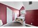 Small bedroom featuring red walls, a single bed, and a single window for natural light at 910 Cypress Ave, St Cloud, FL 34769