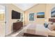Bedroom boasts vaulted ceilings, natural light, and flat screen television above dresser at 910 Cypress Ave, St Cloud, FL 34769