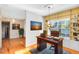 Bright office space with a wooden desk, built-in shelves, and a cozy seating area at 910 Cypress Ave, St Cloud, FL 34769