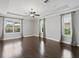 Spacious bedroom featuring a tray ceiling, ceiling fan, large windows, and hardwood floors at 922 Home Grove Dr, Winter Garden, FL 34787