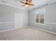 Cozy bedroom features neutral carpet, trim, and a lighted fan at 922 Home Grove Dr, Winter Garden, FL 34787