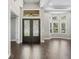 Bright foyer with hardwood floors, decorative doors, high ceilings, and a glimpse of the outdoor scenery at 922 Home Grove Dr, Winter Garden, FL 34787