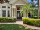 Elegant front entrance with decorative doors, lush landscaping, and architectural columns creating a grand welcome at 922 Home Grove Dr, Winter Garden, FL 34787