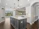 Spacious kitchen with white cabinets, marble countertops, a gray island and modern pendant lighting at 922 Home Grove Dr, Winter Garden, FL 34787