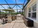 Outdoor kitchen featuring a stainless steel grill and barstool seating, all under a screened enclosure at 922 Home Grove Dr, Winter Garden, FL 34787