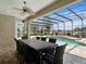Covered patio with dining table looking out to a screened pool area at 922 Home Grove Dr, Winter Garden, FL 34787