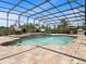 Screened pool area with two lounge chairs, an umbrella, and an outdoor kitchen at 922 Home Grove Dr, Winter Garden, FL 34787
