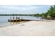 Sandy beach and dock offer a tranquil spot by the lake, perfect for relaxing and enjoying waterfront activities at 934 Deerwood Loop, Longwood, FL 32779