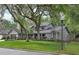 Charming home with lush front lawn, mature trees, and painted brick accents enhancing curb appeal at 934 Deerwood Loop, Longwood, FL 32779