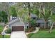 Beautiful residence with an attached garage, lush landscaping, and mature trees creating a private and inviting atmosphere at 934 Deerwood Loop, Longwood, FL 32779