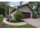 Attached garage with a stylish wood-look door and well-maintained landscaping creates an attractive and functional space at 934 Deerwood Loop, Longwood, FL 32779