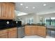 Kitchen with stainless steel dishwasher, light wood cabinets, and black tile backsplash at 934 Deerwood Loop, Longwood, FL 32779