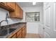Spacious laundry room with oak cabinets, laminate countertop, utility sink, window, and washer at 934 Deerwood Loop, Longwood, FL 32779