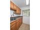 Laundry room with oak cabinets, laminate countertop, utility sink, window, and washer hookups at 934 Deerwood Loop, Longwood, FL 32779
