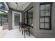 Comfortable outdoor patio area with bistro table and chairs beneath the covered porch at 934 Deerwood Loop, Longwood, FL 32779