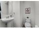 Clean half-bathroom featuring modern fixtures, stylish art, and a pedestal sink at 9349 Sweet Maple Ave, Orlando, FL 32832