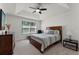 Bright bedroom with a tray ceiling, ceiling fan, wood furniture and neutral color scheme at 9349 Sweet Maple Ave, Orlando, FL 32832