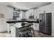 Bright kitchen boasts white cabinets, stainless steel appliances, and a functional center island with seating at 9349 Sweet Maple Ave, Orlando, FL 32832