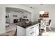 Kitchen island with stone countertop and seating, open to the living and dining areas at 9349 Sweet Maple Ave, Orlando, FL 32832