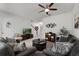 Cozy living room showcasing carpet floors, white walls, ceiling fan, and staircase at 9349 Sweet Maple Ave, Orlando, FL 32832