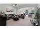 Bright living room with sofas, ceiling fan, archway to kitchen, carpet and neutral walls at 9349 Sweet Maple Ave, Orlando, FL 32832