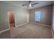 Spacious carpeted bedroom with ceiling fan, window, and a door leading to the ensuite bathroom at 0 Sabal St, Orlando, FL 32833