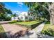 Elegant two-story white home with well-maintained landscaping, a brick driveway and sidewalk at 1106 Ayrshire St, Orlando, FL 32803
