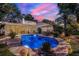 Backyard oasis with sparkling pool, elegant patio furniture, and ambient string lighting at dusk at 1106 Ayrshire St, Orlando, FL 32803