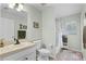 Bathroom featuring a toilet, shower, and vanity with a sink, complemented by natural light from a window at 1124 Shadowbrook Trl, Winter Springs, FL 32708