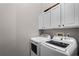 Bright laundry room with modern washer and dryer units and upper cabinets at 1124 Shadowbrook Trl, Winter Springs, FL 32708