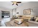Open-concept living room featuring a comfortable sectional sofa, plush rug, and serene artwork at 1124 Shadowbrook Trl, Winter Springs, FL 32708