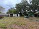 A spacious backyard features a shed, small backhoe and lawn covered in leaves at 11625 Churchill St, Orlando, FL 32817