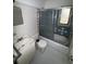 Full bathroom with a blue tiled shower-tub combo, toilet, and vanity at 11625 Churchill St, Orlando, FL 32817