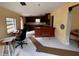 Spacious living room with unfinished floors, an open kitchen with dark wood cabinets, and natural light at 11625 Churchill St, Orlando, FL 32817