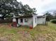 Rear exterior view of a home showing block construction and lawn at 11625 Churchill St, Orlando, FL 32817